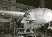 A 9th Armored Division soldier guards a captured Me 163 Komet rocket-powered fighter