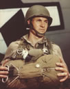 A pigeon in a sling ready for a jump with a US paratrooper (National Archives)